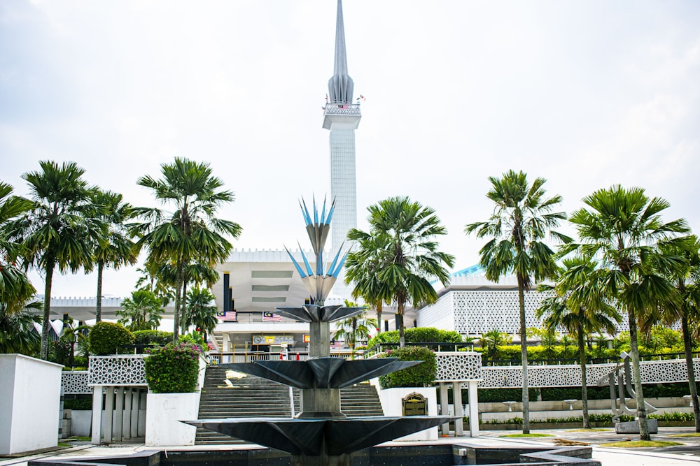 a fountain with a clock tower in the background