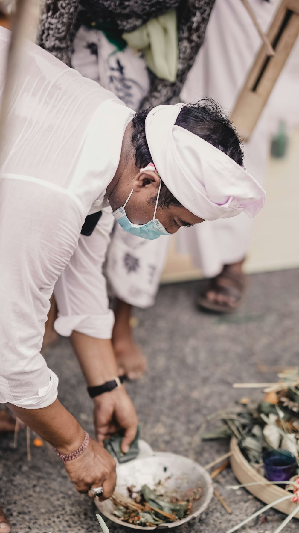 a man wearing a surgical mask is cutting up food