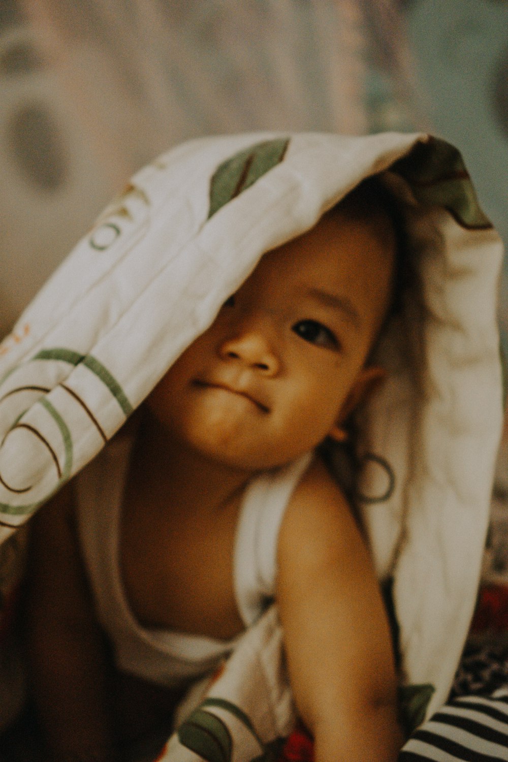 a baby is laying down under a blanket