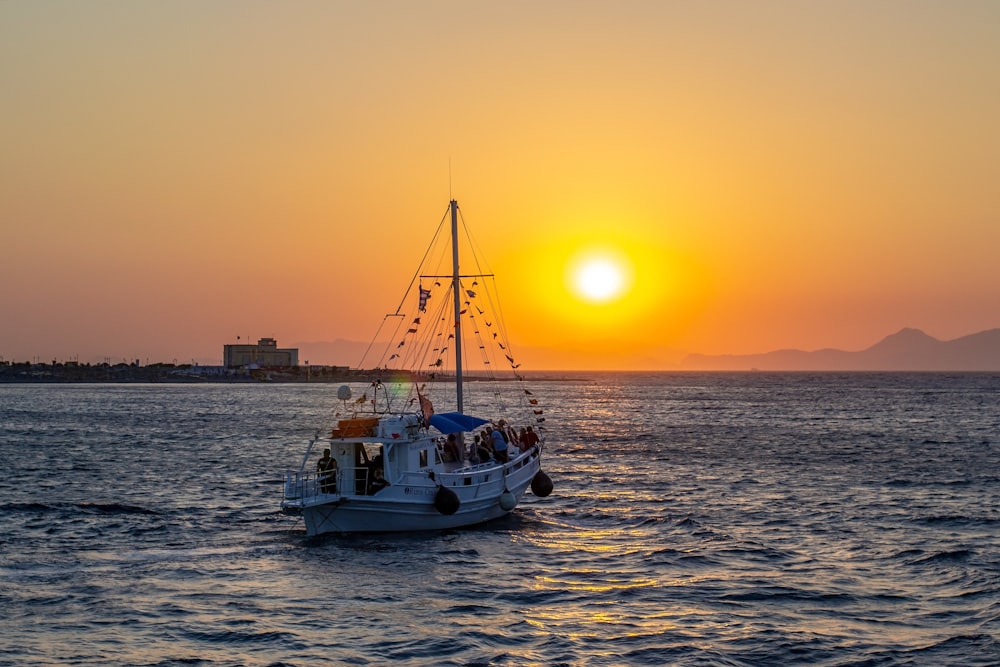 Ein Boot im Wasser mit der untergehenden Sonne im Hintergrund