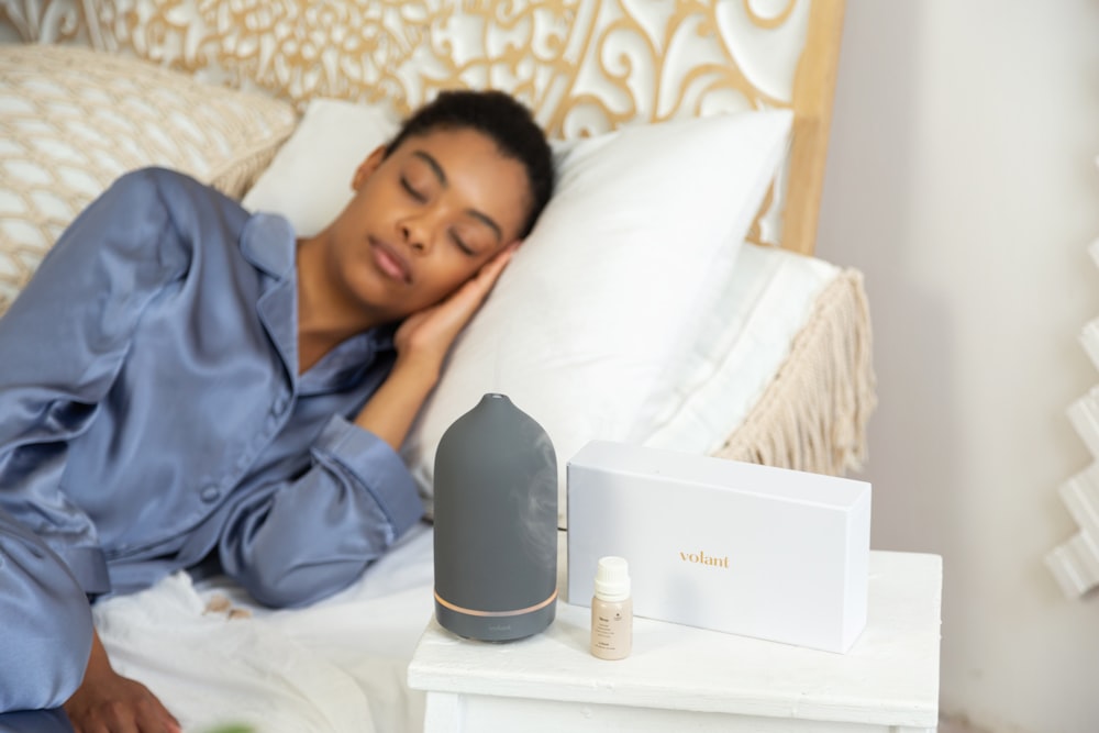 a woman laying on a bed next to a night stand