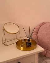 Close-up of a dresser with intricate gold detailing and smooth surfaces reflecting ambient light.