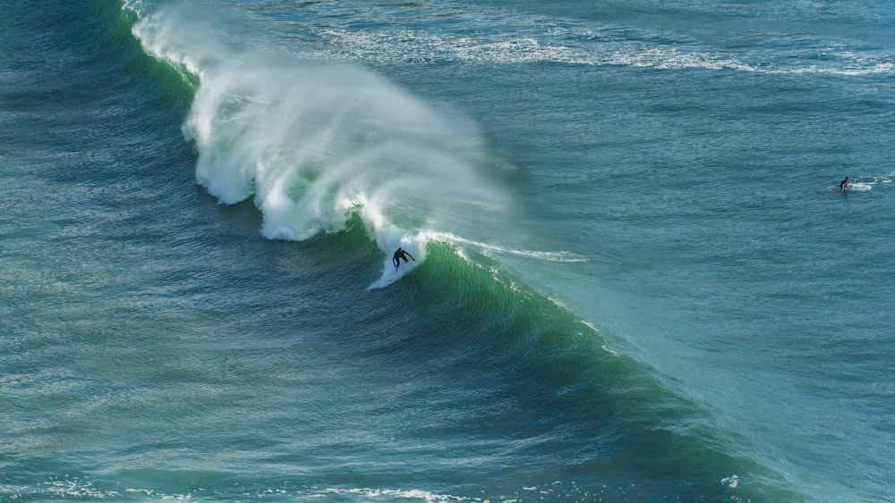 a person riding a wave on top of a surfboard