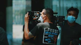 a man wearing a face mask while holding a camera