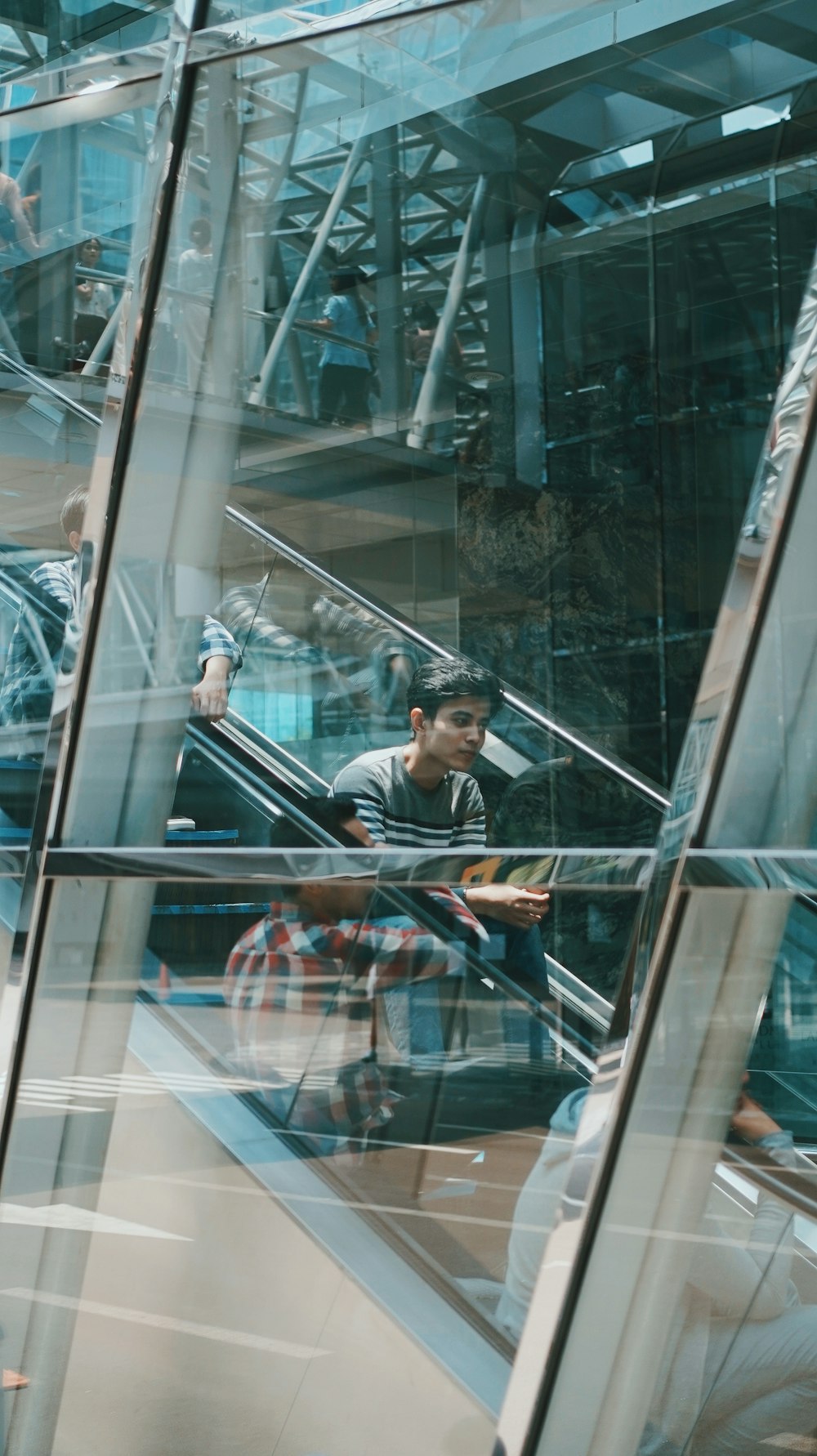 a man sitting on an escalator in a building