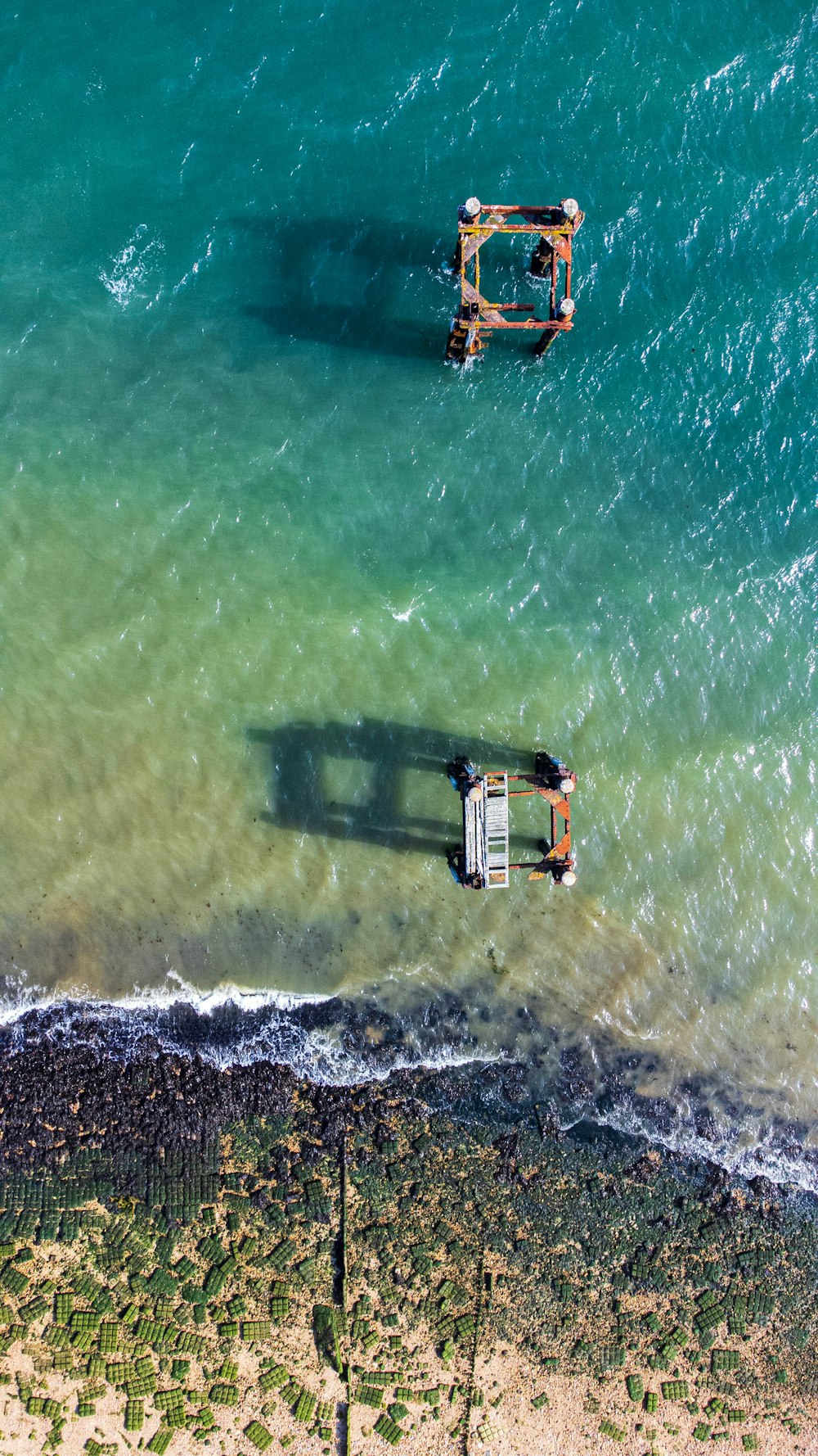 an aerial view of a beach with a boat in the water