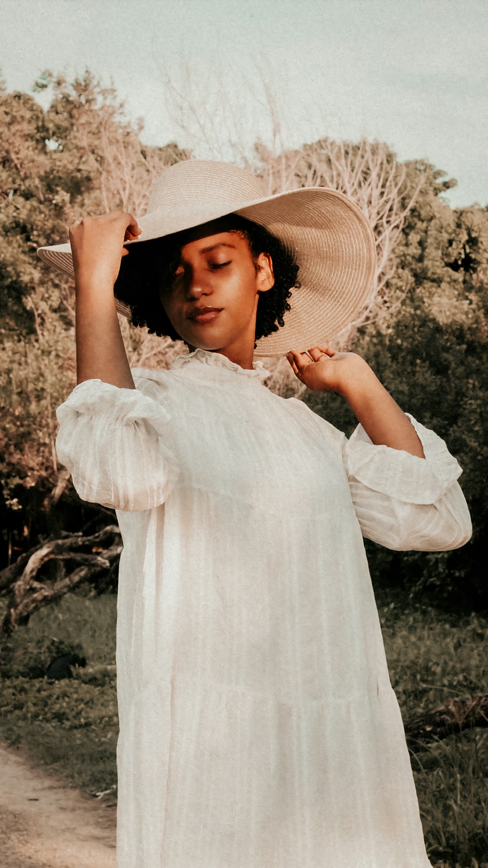 a woman in a white dress and hat