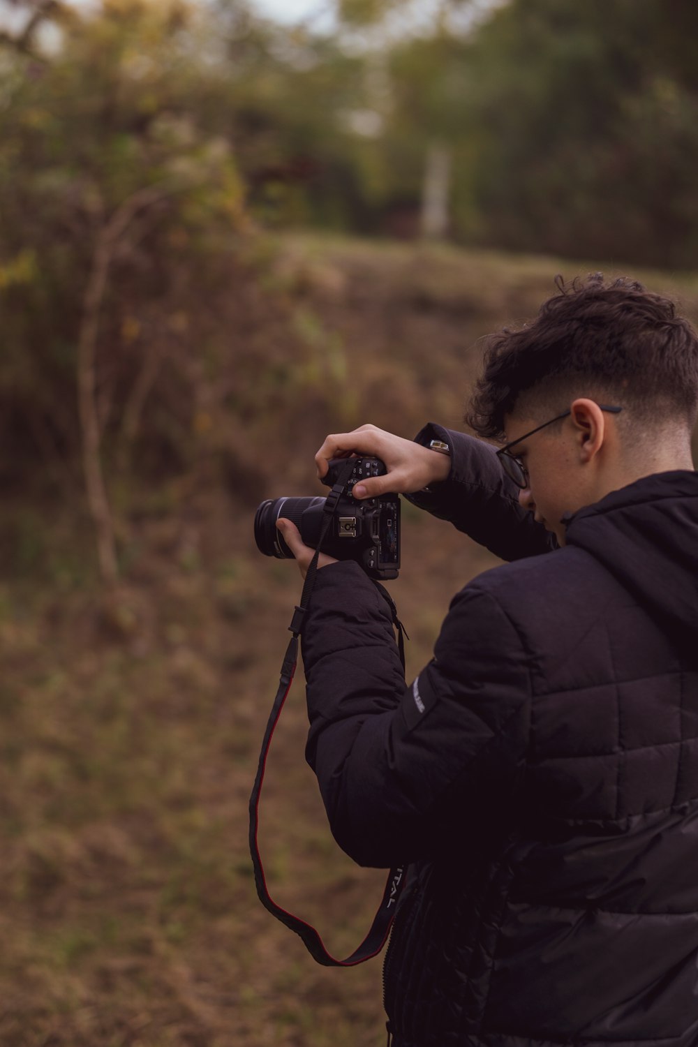 a man taking a picture of a field with a camera