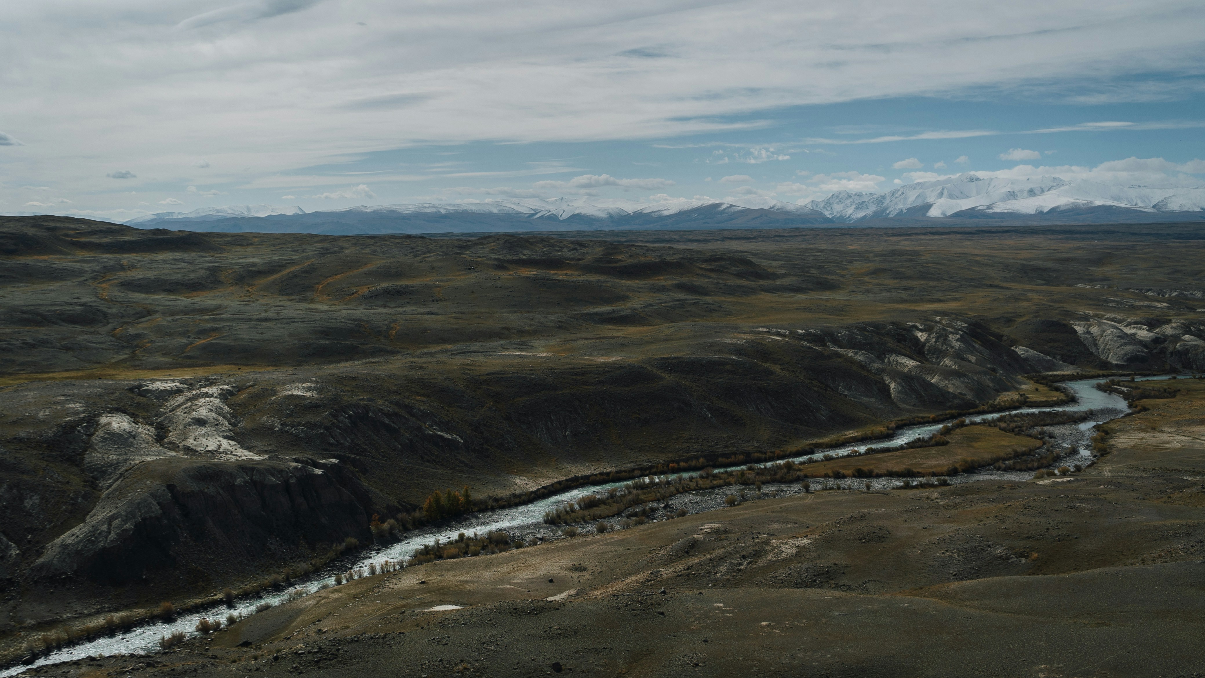 a river running through a valley surrounded by mountains