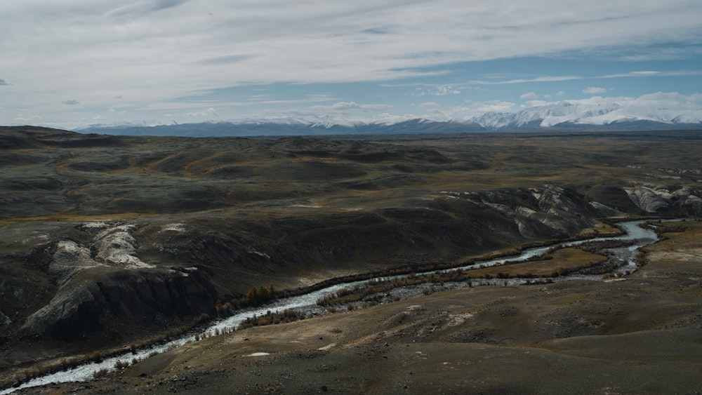 a river running through a valley surrounded by mountains