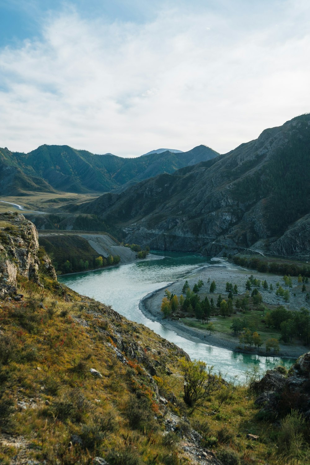 a river running through a valley surrounded by mountains