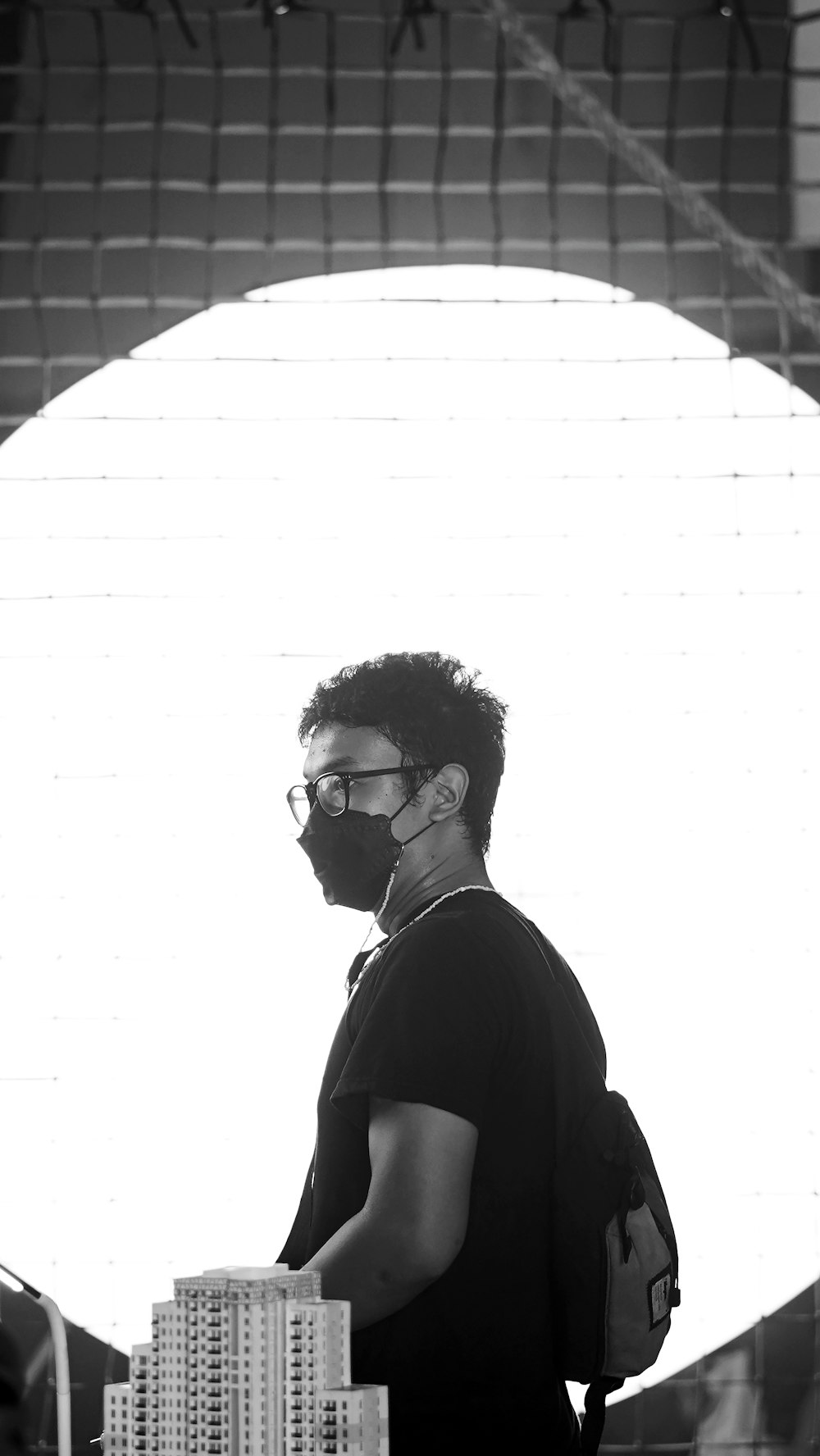 a man with a beard and glasses standing in front of a building