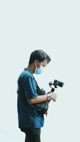 a man wearing a face mask while holding a camera