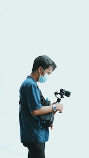 a man wearing a face mask while holding a camera