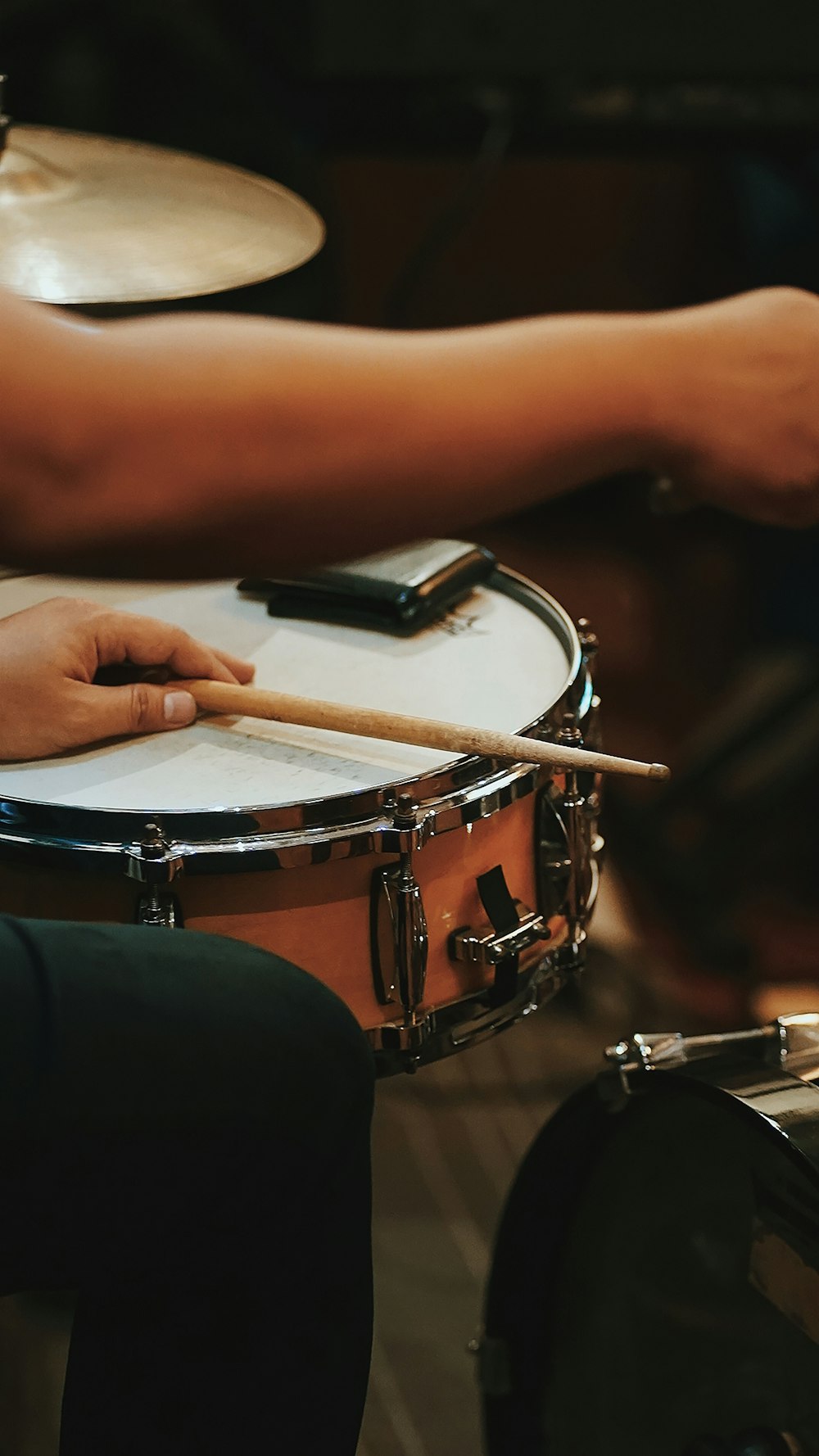 a person playing a drum with a pair of hands