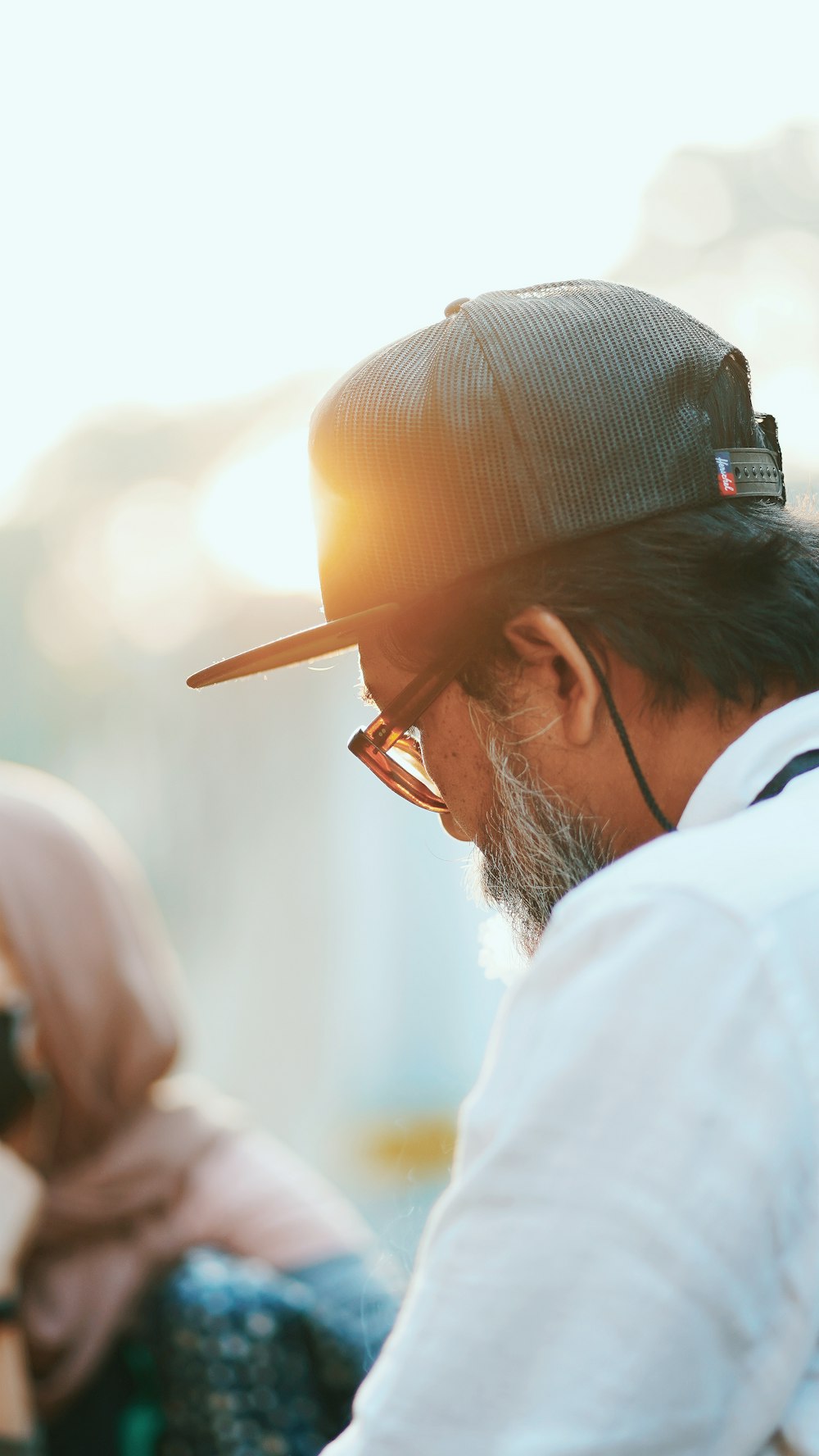 a man wearing a hat and glasses looking at his cell phone