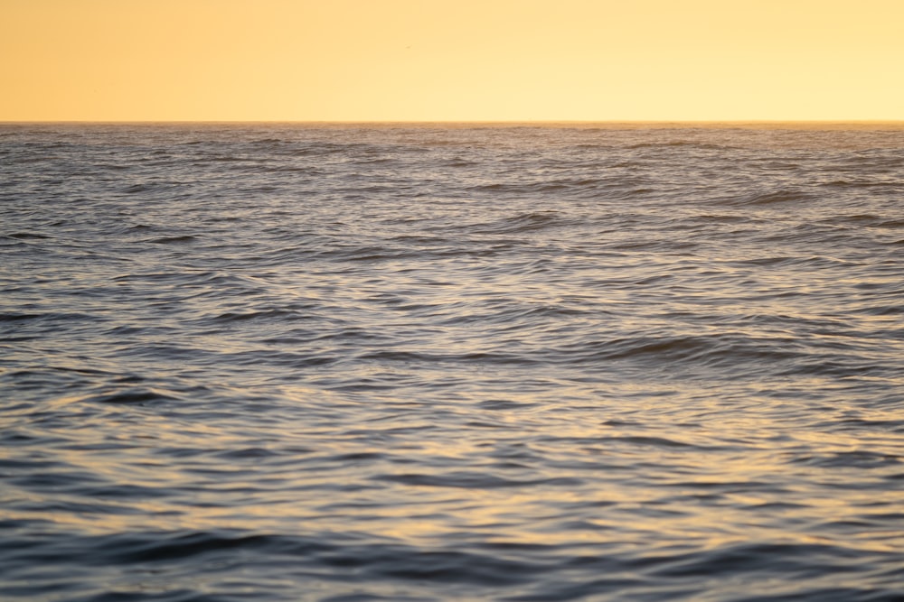 a large body of water with a boat in the distance