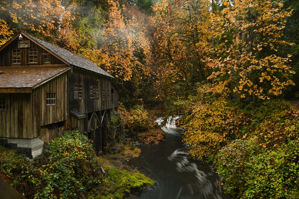 a wooden building surrounded by trees and water