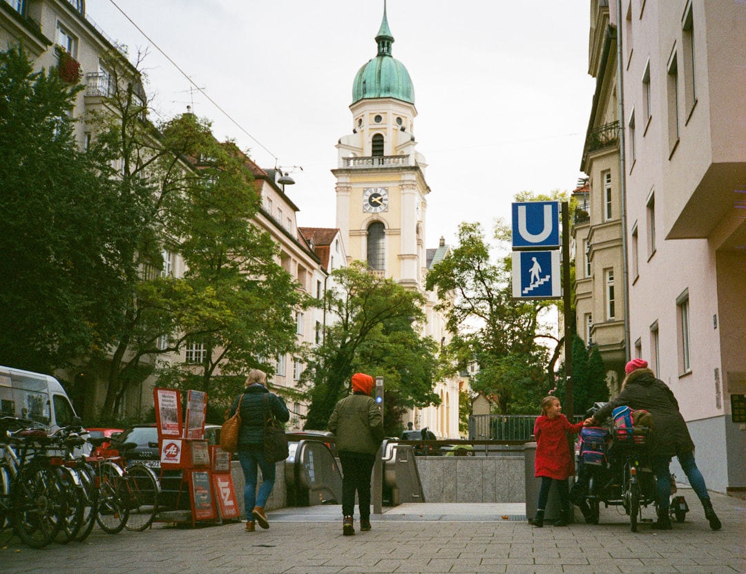 a group of people walking down a street next to tall buildings, München streets<p></figure>Olympus XA, Fujifilm Superia X-Tra 400