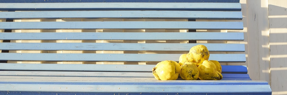 a bunch of bananas sitting on a blue bench