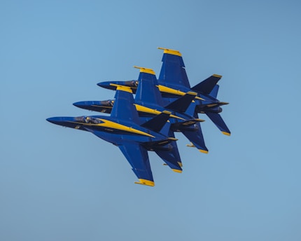a group of fighter jets flying through a blue sky