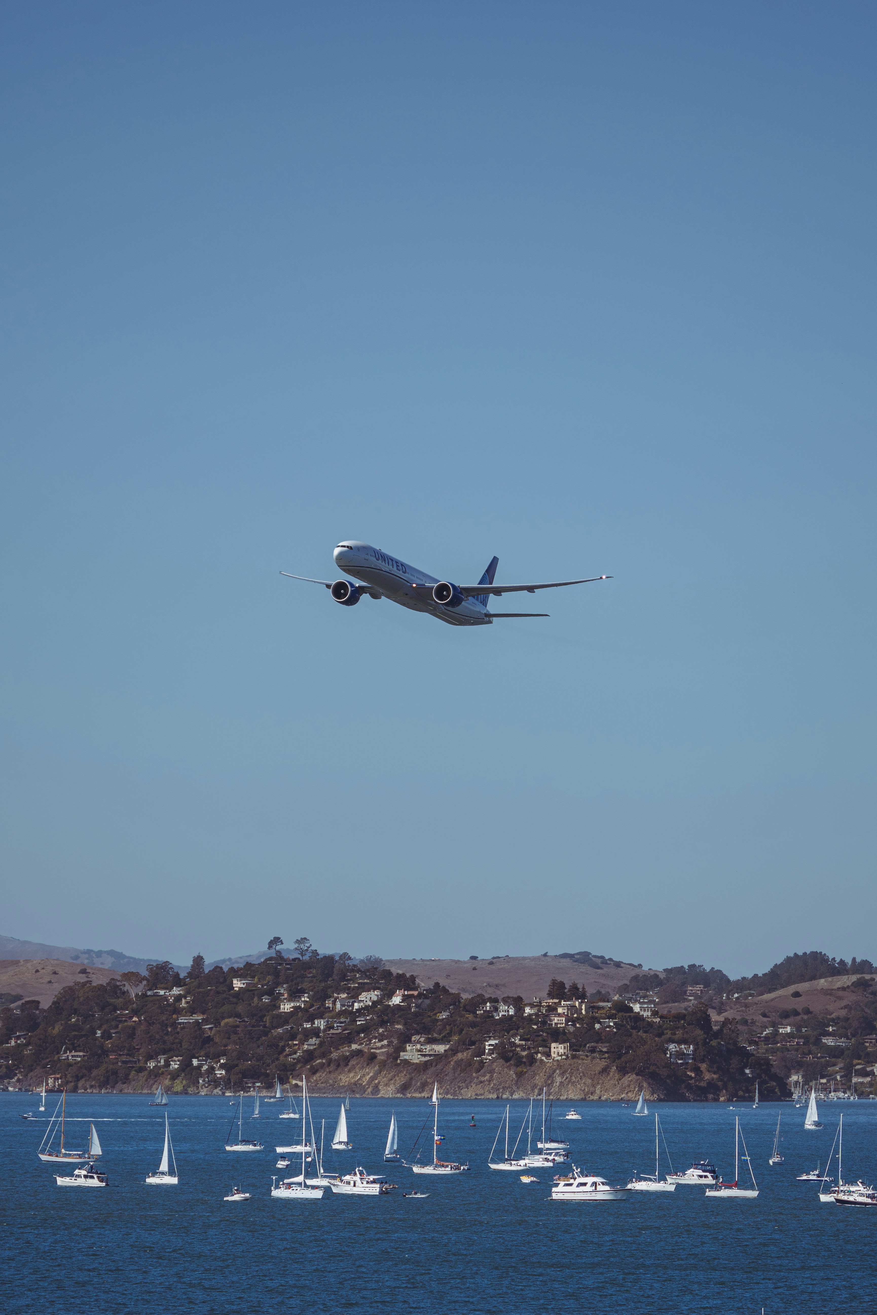 a large jetliner flying over a body of water
