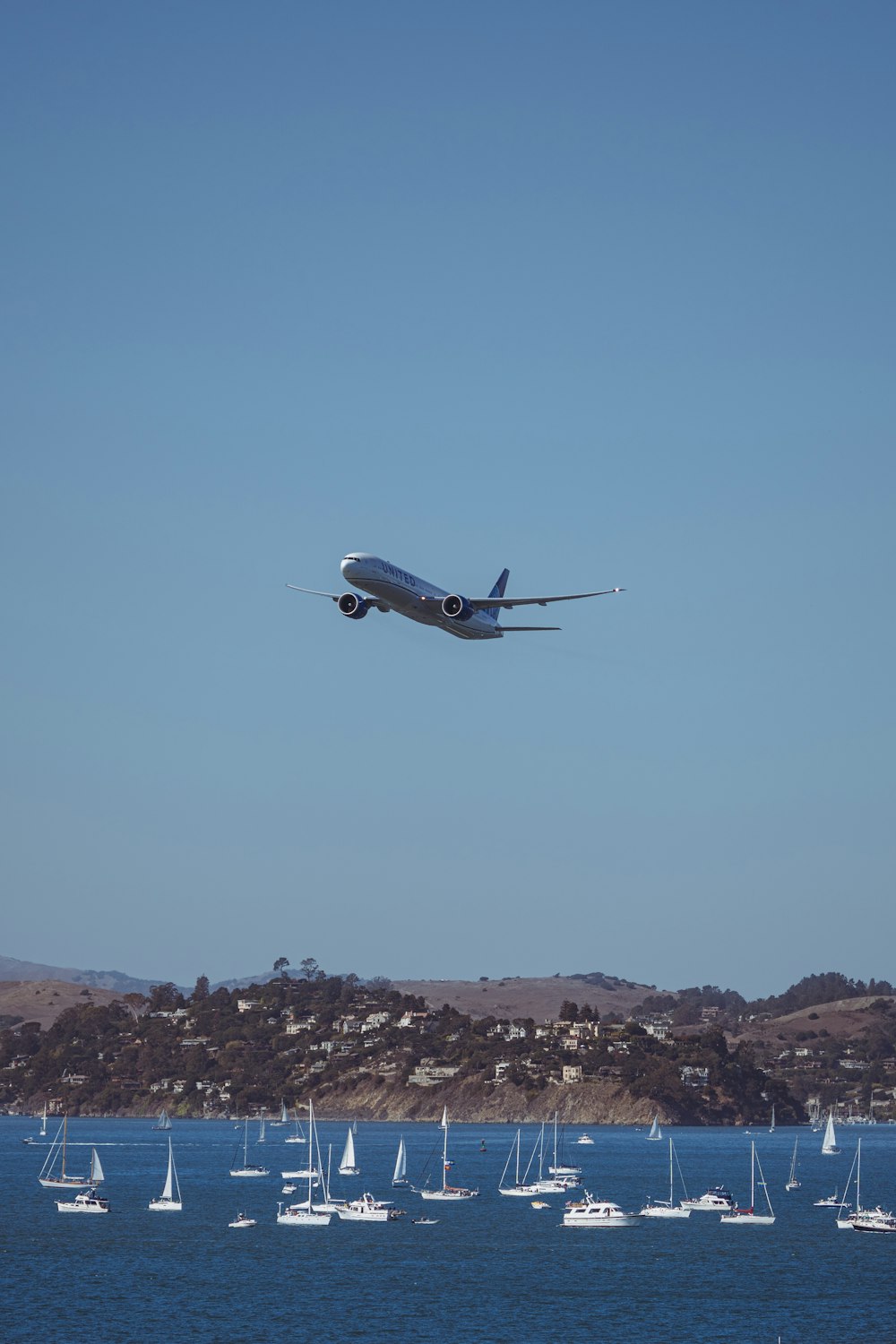 a large jetliner flying over a body of water