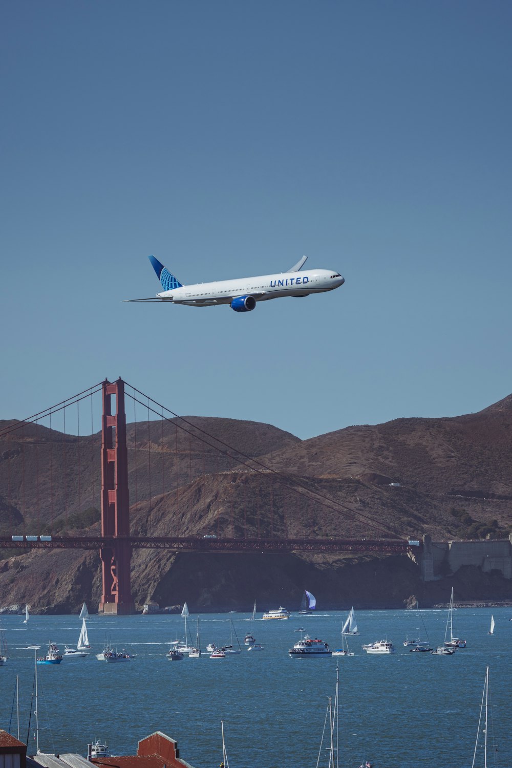 a large jetliner flying over a body of water