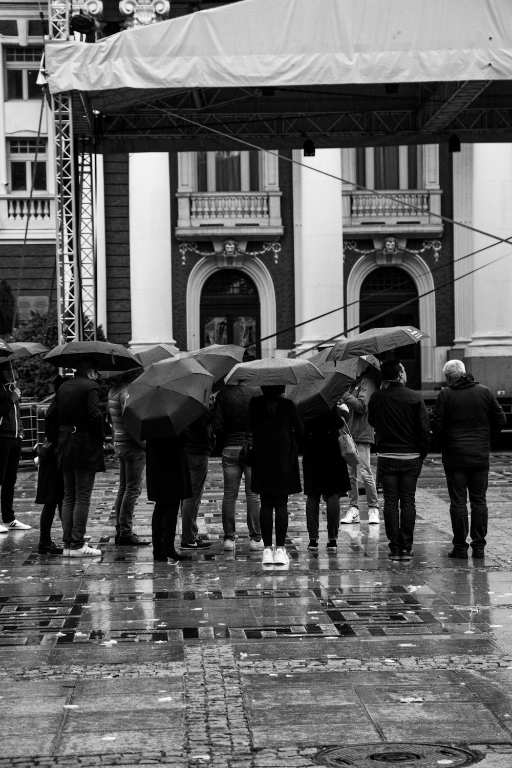 a group of people with umbrellas standing in the rain