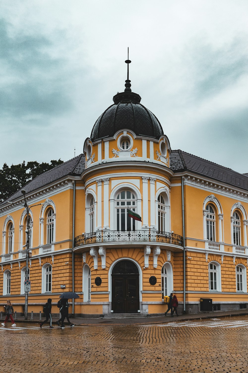 Un grande edificio giallo con un tetto nero