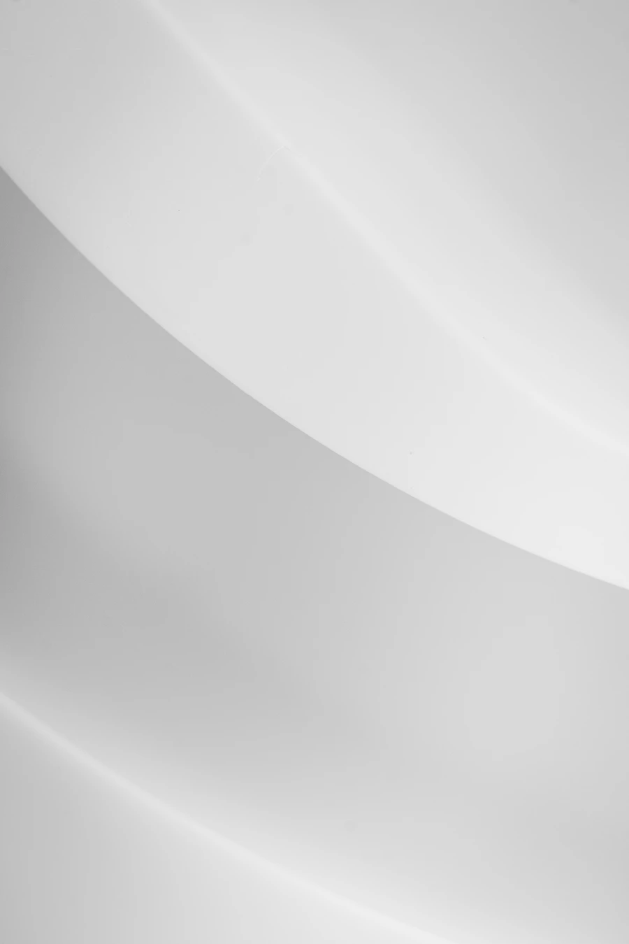Smooth white curved surfaces meeting in soft grey shadow