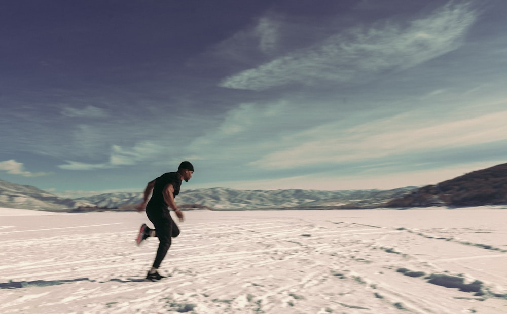 a man riding a snowboard across a snow covered field