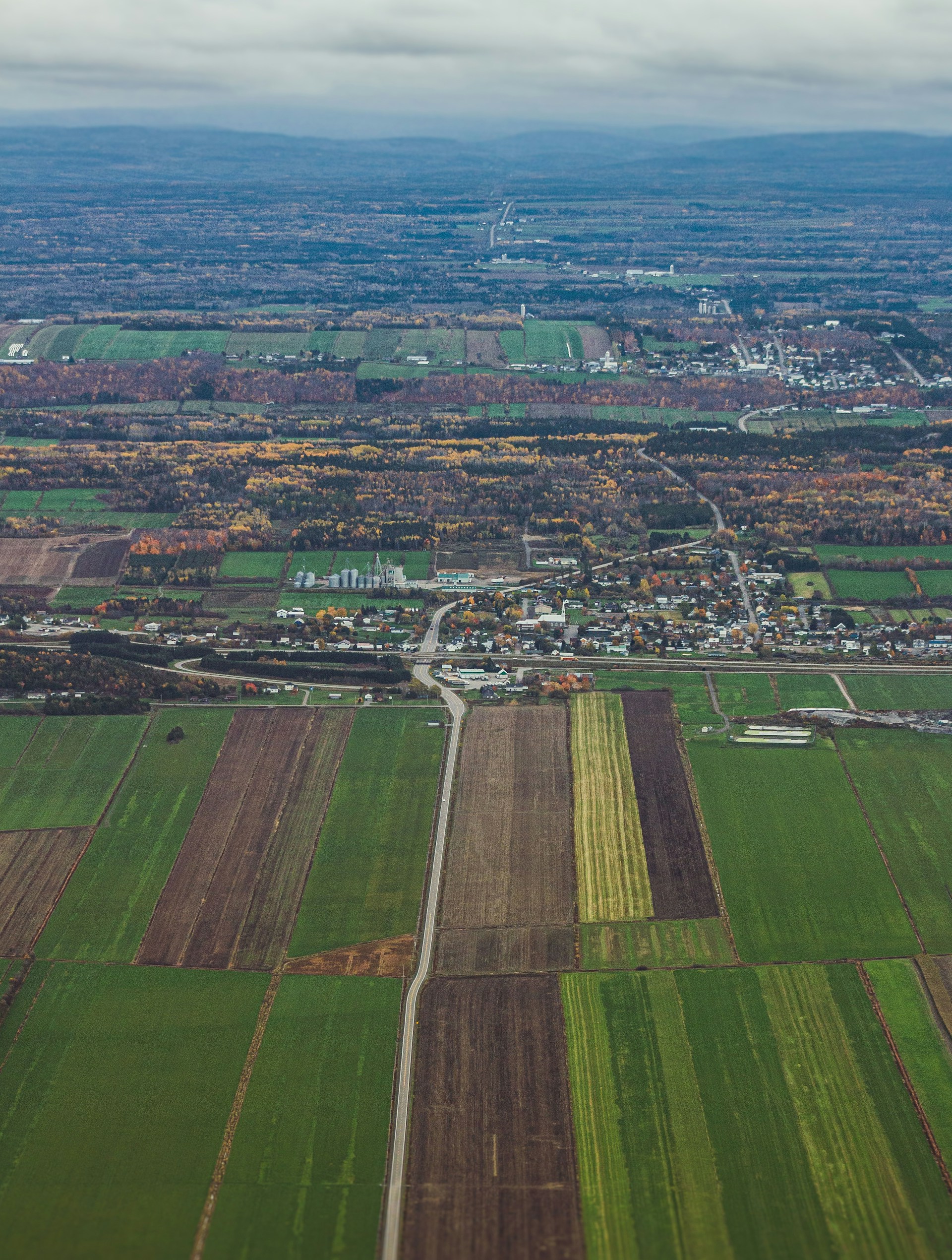 an aerial view of a field with a city in the distance