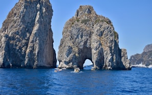 a group of people in kayaks in front of a rock formation