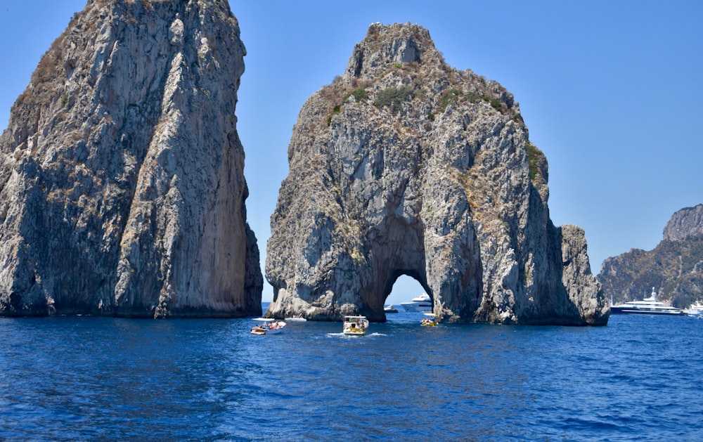 a group of people in kayaks in front of a rock formation