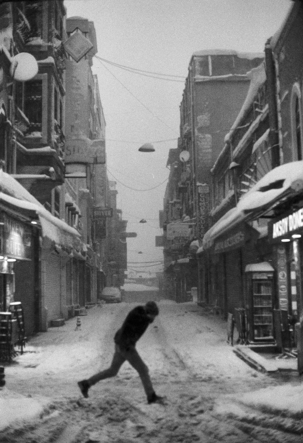 a man walking down a snow covered street