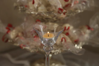 Warm glowing candlelit scene featuring a minimalist black and gold gift box amidst soft shadows.