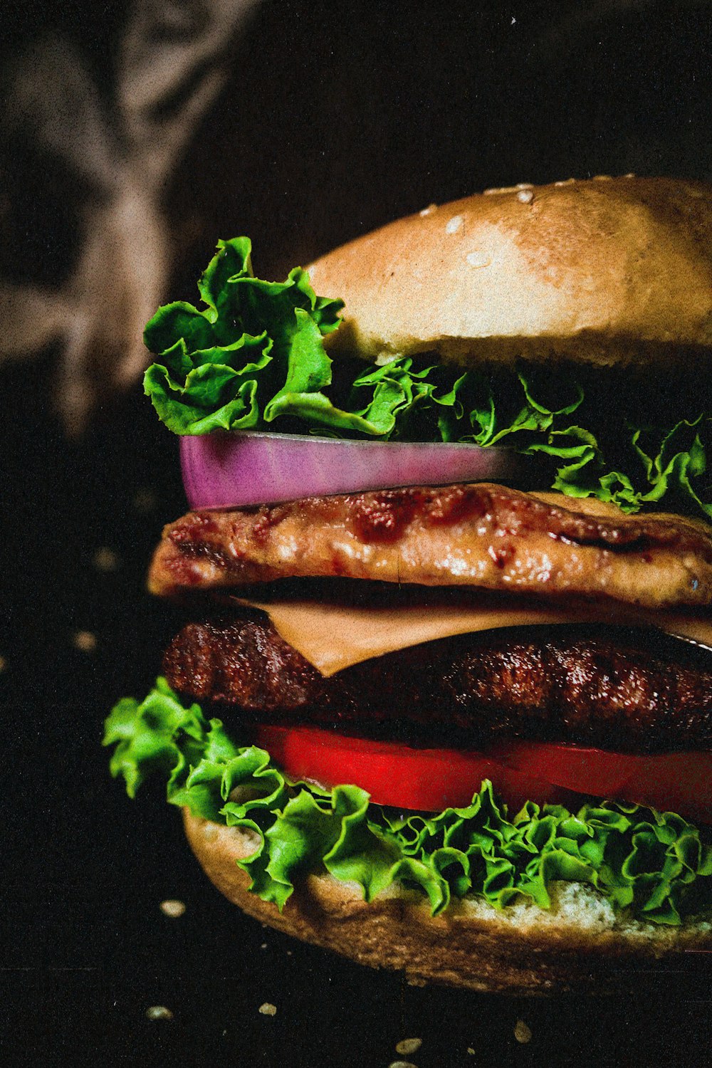 a hamburger with lettuce, tomato, and meat