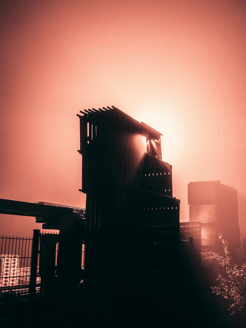 a black and white photo of a building in the fog