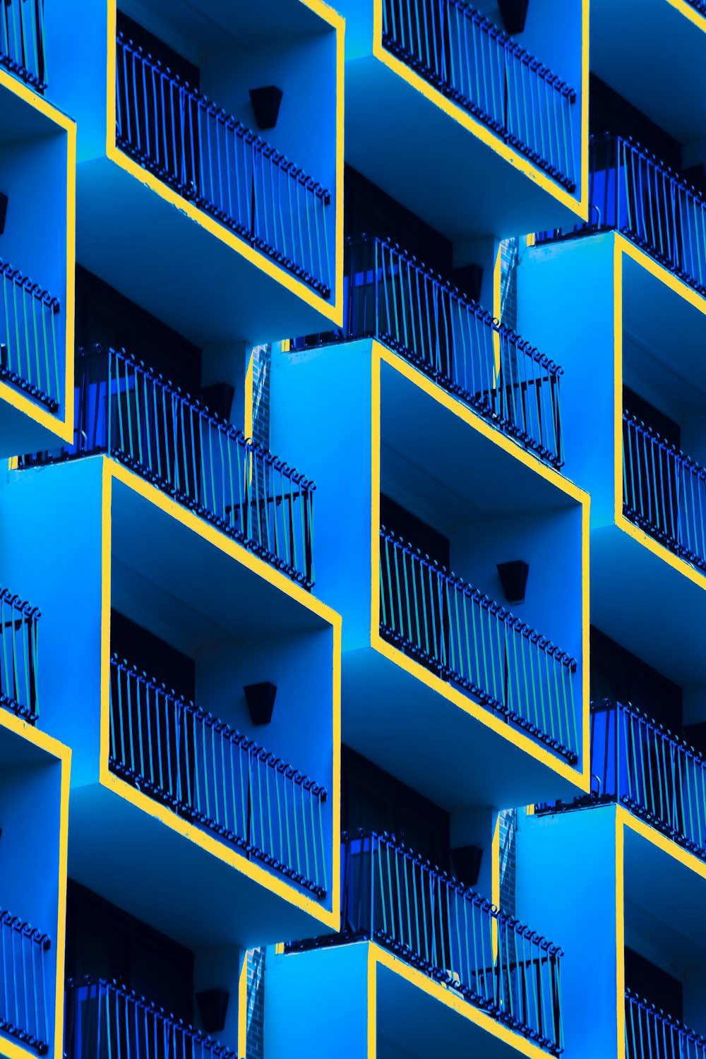 a building with balconies and balconies painted blue and yellow
