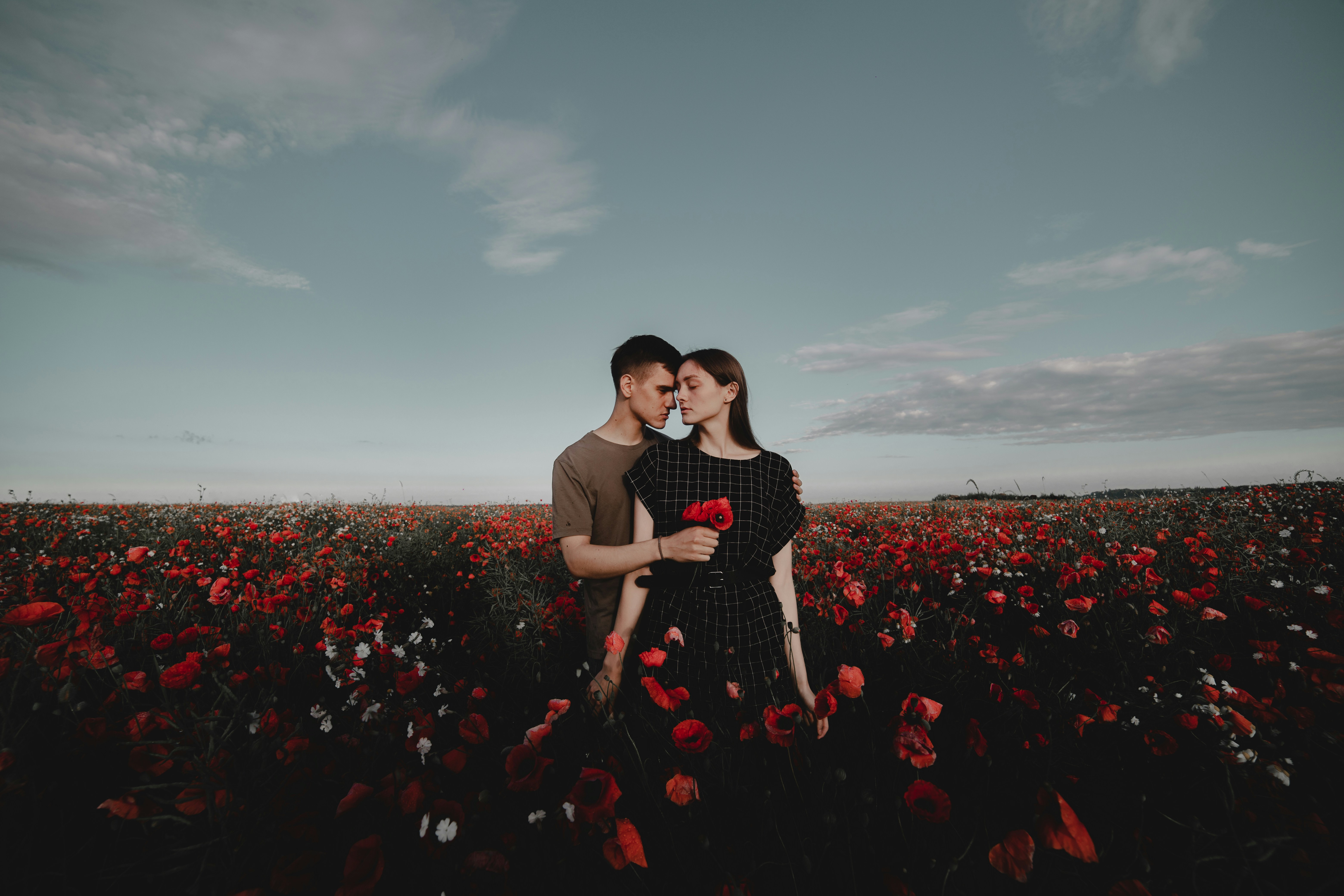 A man and a woman standing in a field of flowers photo – Free Flower ...
