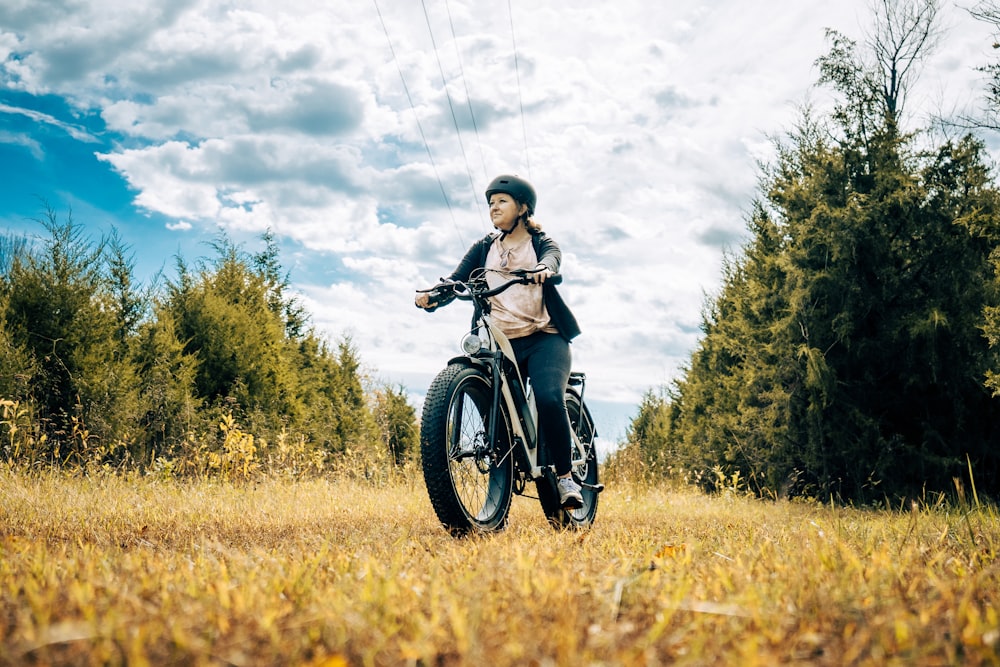 a woman riding a motorcycle in a field