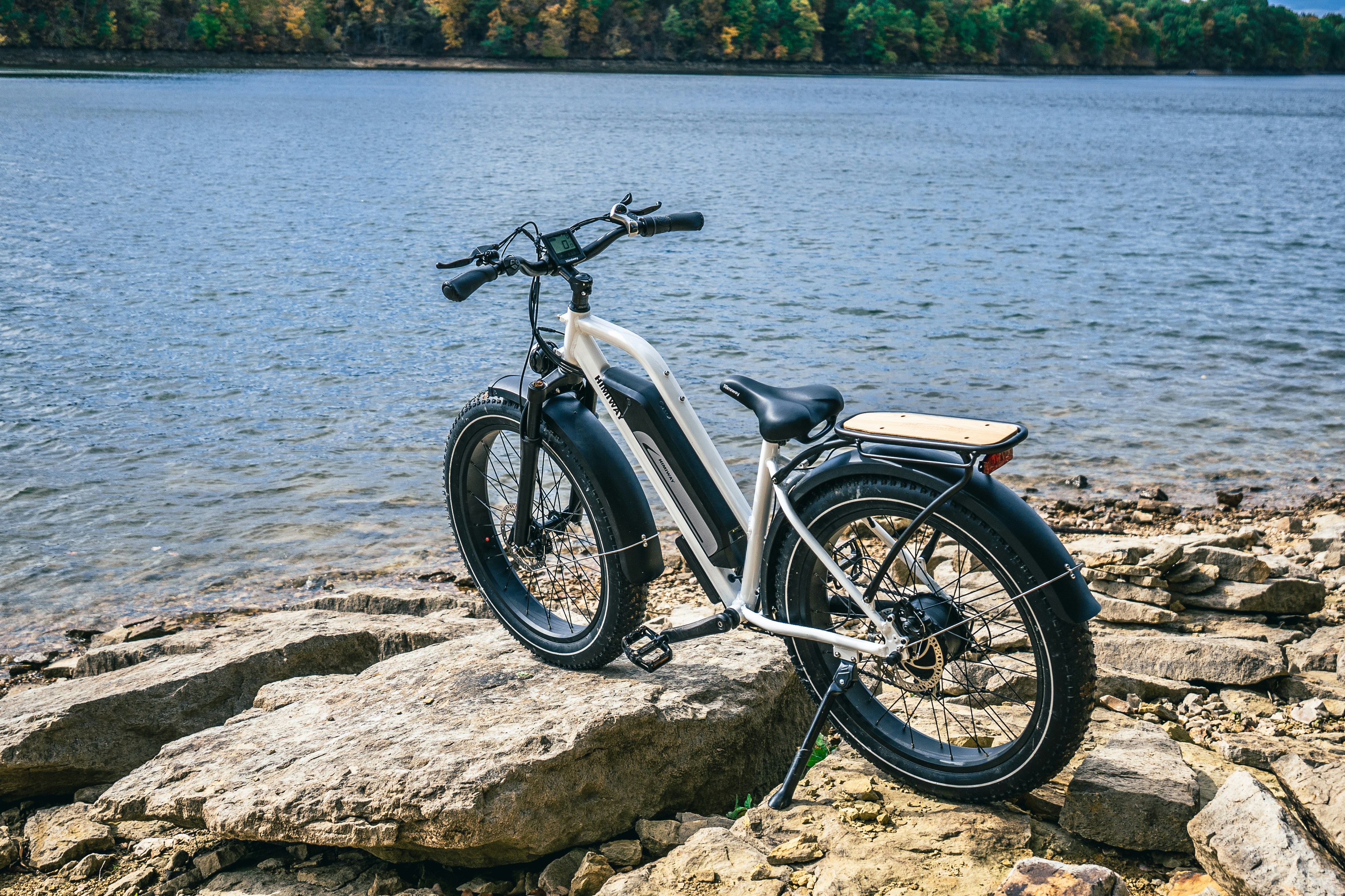 a motorbike parked on a rocky shore by the water