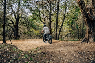 a man riding a bike through a forest