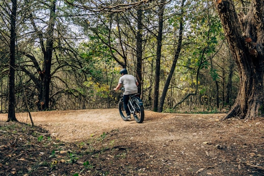 a man riding a bike through a forest