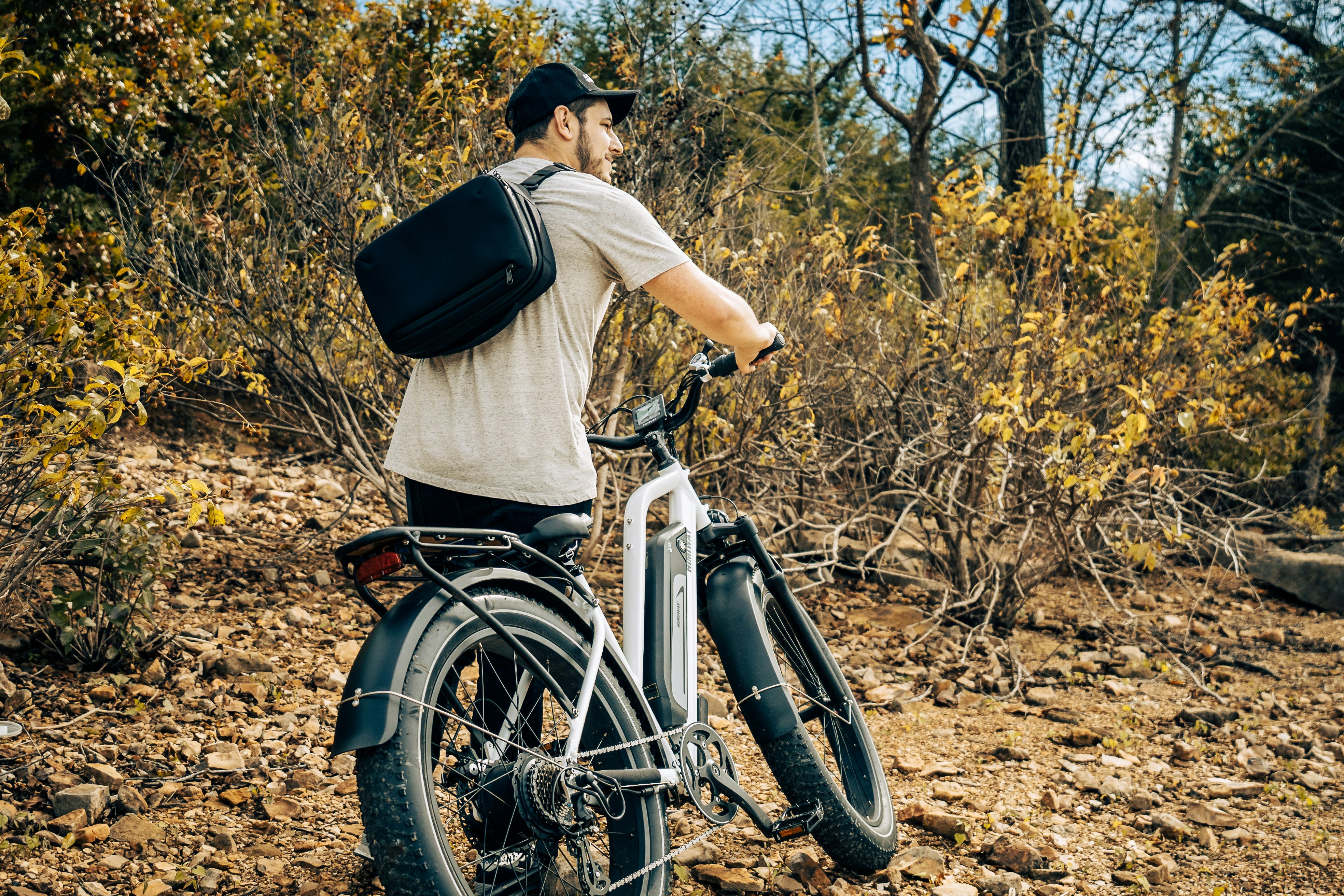 a man with a backpack is riding a bike