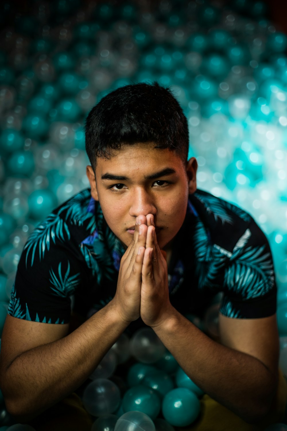 a man sitting in front of a pile of balls