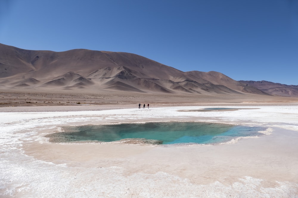 a group of people standing on top of a desert