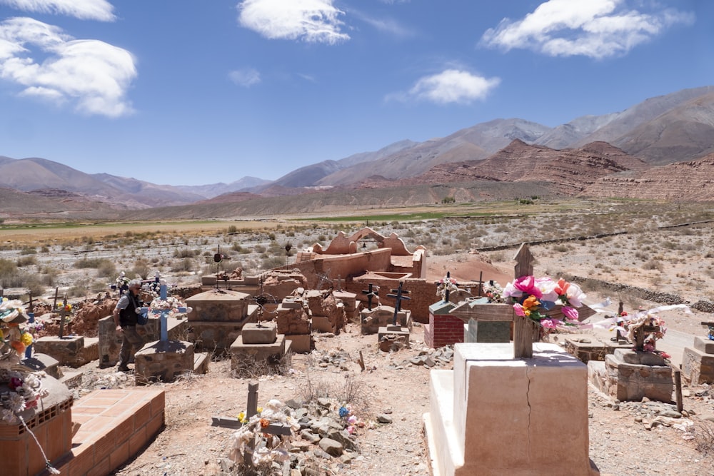 a cemetery in the middle of a desert with mountains in the background