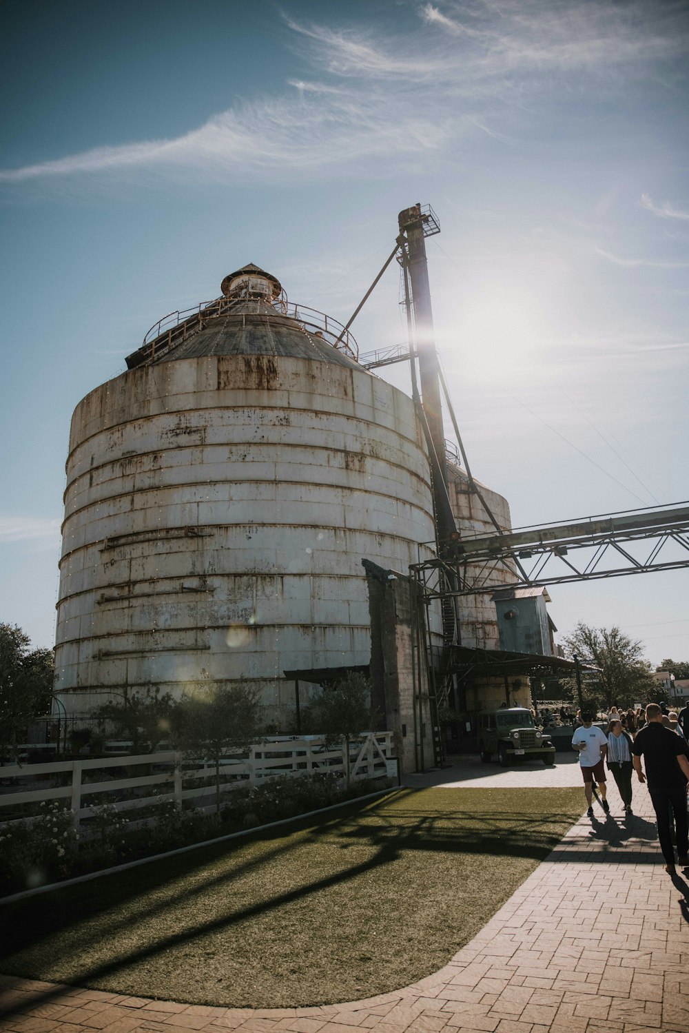 a group of people standing outside of a large silo